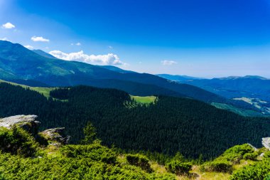 Yeşil ve mavi bulutlu gökyüzü ile büyüleyici doğa dağ manzaralı