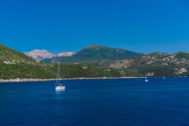 yüzen tekneler ile mavi deniz suyu, arka planda ada 