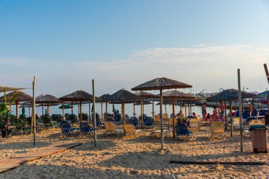 Dinlenen insanlar ve şemsiyeler ile kumlu plaj 