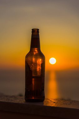 Gün batımı gökyüzüne karşı şişe yakın
