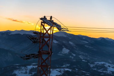 dağlarda güzel gün batımı gökyüzü ve kablolar ile elektrik kulesi 