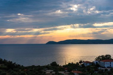 günbatımı gökyüzü kıyıdan görmüş deniz suyu yansıtan