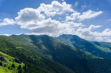 Yeşil ve mavi bulutlu gökyüzü ile büyüleyici doğa dağ manzaralı