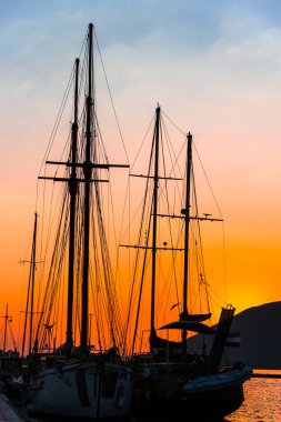 Dramatik gün batımı gökyüzüne karşı gemilerle liman