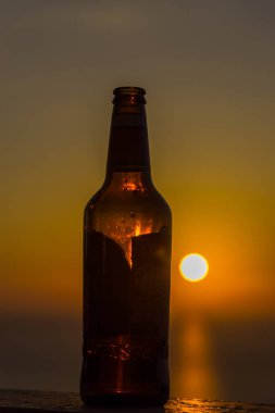 Gün batımı gökyüzüne karşı şişe yakın