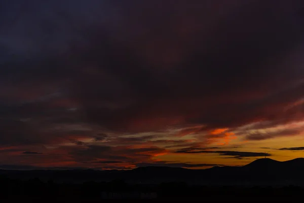 丘の上の劇的な曇り夕焼け空 — ストック写真