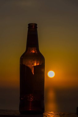 Gün batımı gökyüzüne karşı şişe yakın