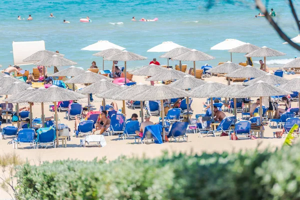 海の砂浜にあるビーチ傘や椅子ビーチにいる人たちは — ストック写真