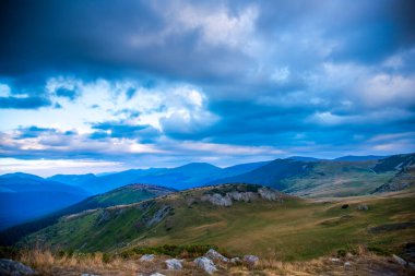 Bulutlu ve mavi gökyüzü olan dağ manzarası