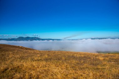 Bulutlu ve mavi gökyüzü olan dağ manzarası