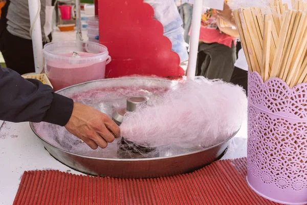 Pink cotton candy. Salesman are spinning the color of sugar with a spinning step. Sweet taste by food machine process