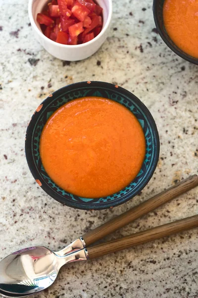 Spanish Gazpacho cold vegetable soup made of tomato, cucumber, bell pepper, onion, garlic and olive oil served in ceramic bowl . top view