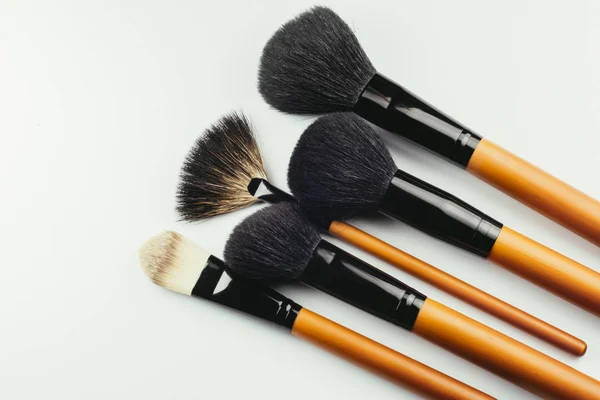 Various wooden makeup brushes isolated over white