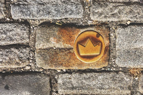 Slovakia, Bratislava. Brass crown marker in cobblestone streets show location of the coronation walk. Old town