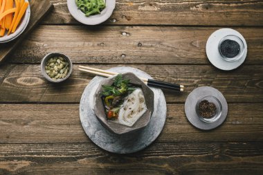 Asya şehriye çorbası geometrik kase yemek çubukları, ahşap masa ve taze sebze ile