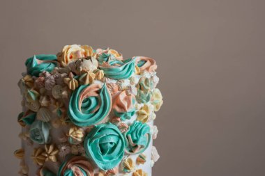 Çiçekler, pastel renkler şeklinde İsviçre beze pasta süslenmiş.