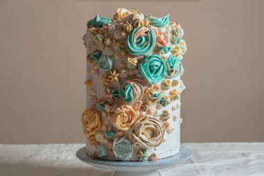 Çiçekler, pastel renkler şeklinde İsviçre beze pasta süslenmiş.