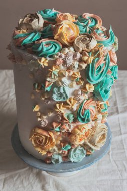 Çiçekler, pastel renkler şeklinde İsviçre beze pasta süslenmiş.