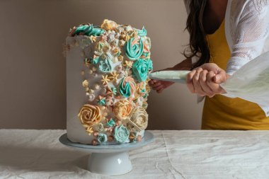 Kadın pasta şefi kremalı pasta çantası ile bir pasta süsleme