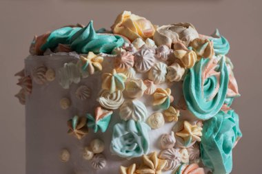 Çiçekler, pastel renkler şeklinde İsviçre beze pasta süslenmiş.