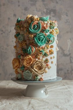 Çiçekler, pastel renkler şeklinde İsviçre beze pasta süslenmiş.