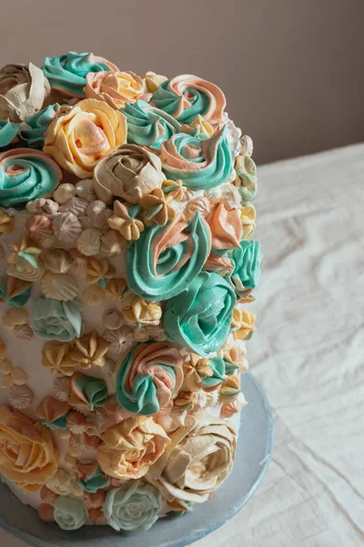 Çiçekler, pastel renkler şeklinde İsviçre beze pasta süslenmiş.