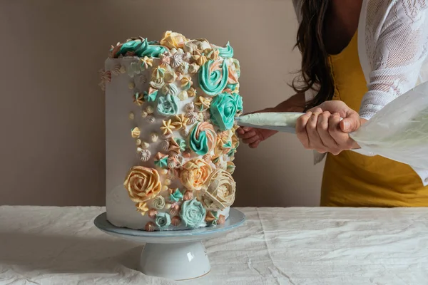 Kadın pasta şefi kremalı pasta çantası ile bir pasta süsleme