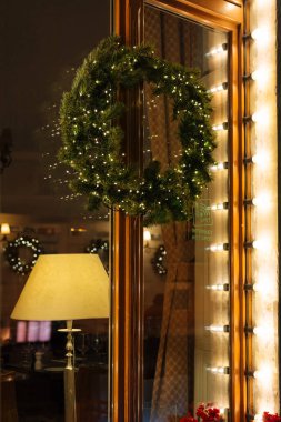 Işıklar, ev girişinde asılı Noel çam çelenk süslenmiş