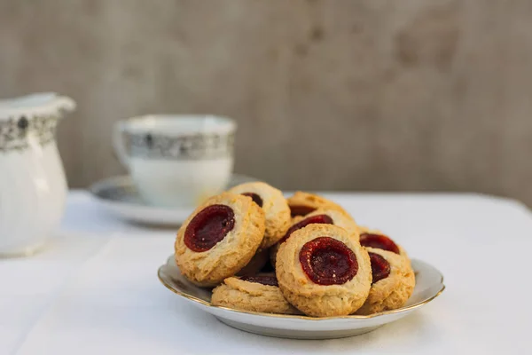 桌上摆满草莓酱的拇指印饼干 时间茶 — 图库照片