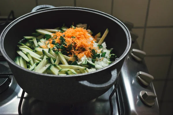 Domestic scene. cooking vegetables by the gas stove. Zucchini and carrot cut into julienne, ready for cooking.