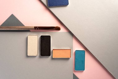 Fotoğraf, pastel geometrik geometrik arka plan üzerinde zarif makyaj. Yukarıdan.