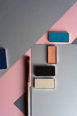 Fotoğraf, pastel geometrik geometrik arka plan üzerinde zarif makyaj. Yukarıdan.