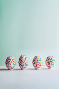 Komik çok renkli Paskalya yumurta boyalı üzerinde yumuşak mavi backgro el