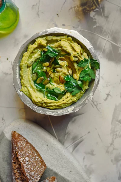 Hummus de aguacate en proa, con semillas de calabaza de aceite de oliva y co fresco Fotos de stock libres de derechos