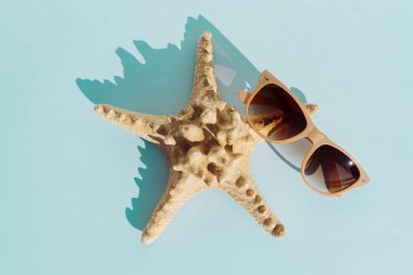 Denizyıldızı ve güneş gözlüğü turkuaz bakground, tavel ve yaz