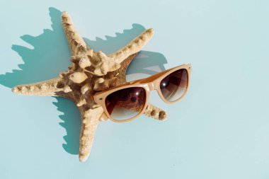 Denizyıldızı ve güneş gözlüğü turkuaz bakground, tavel ve yaz