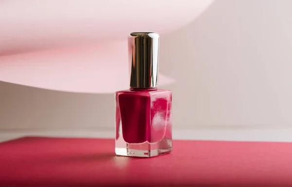 Esmalte de uñas rosa sobre fondo de color pastel Imagen de stock