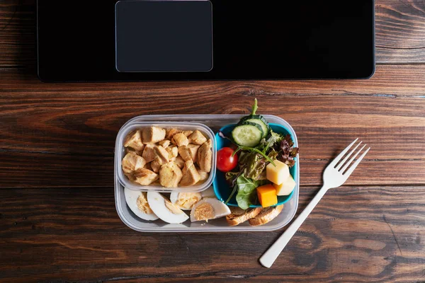 Comida saludable en la lonchera en la mesa de trabajo con portátil — Foto de Stock