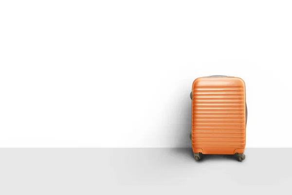 Orangefarbener Koffer neben der Wand, Reisekonzept — Stockfoto