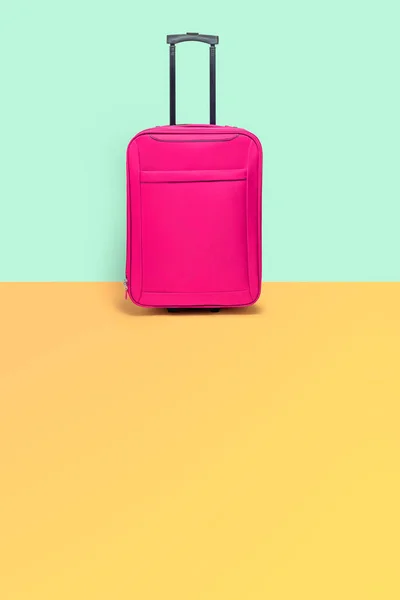 Pinkfarbener Koffer neben der pastellfarbenen Wand. Reisewarnung — Stockfoto