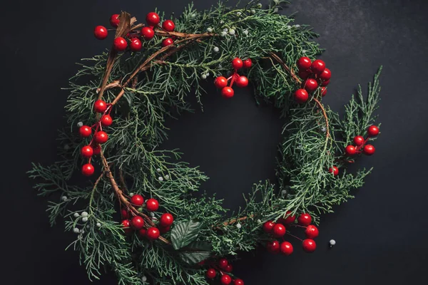 Christmas wreath detail of evergreen and berries on dark backgro — Stock Photo, Image