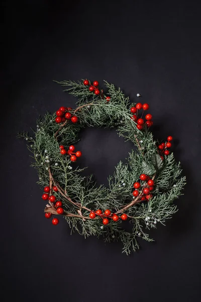 Christmas wreath detail of evergreen and berries on dark backgro — Stock Photo, Image