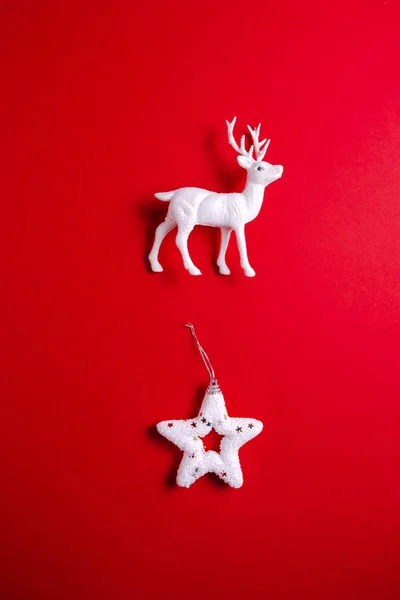 White reindeer toy with christmas star on red background. — Stock Photo, Image