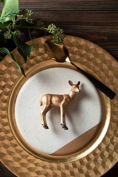 Holiday place setting and toy golden reindeer decoration on the — Stock Photo, Image