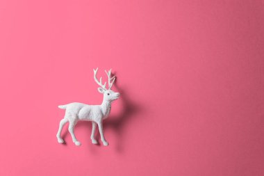 Pembe pastel arka planda beyaz ren geyiği oyuncağı. Tatil Arkaplanı