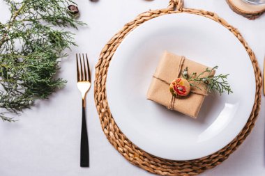 Zarif Noel yeri ayarları, tabağın üstündeki hediye kutusu.