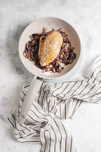 Chicken breast in the pan, on caramelized red onion — Stock Photo, Image