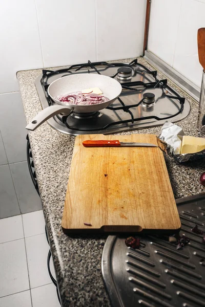 Frigideira com cebola vermelha picada e manteiga no fogo da cozinha — Fotografia de Stock