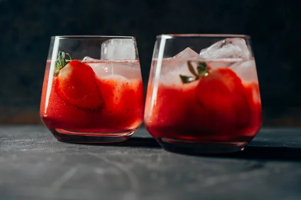 Dos cócteles de fresa con hielo sobre fondo oscuro — Foto de Stock