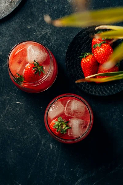 Dos cócteles de fresa con hielo sobre fondo oscuro — Foto de Stock